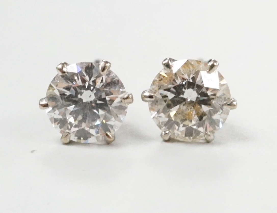 A pair of white metal and solitaire diamond set ear studs